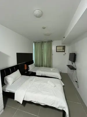 a bedroom with two beds and a window at The Serenity Tower 2011 in Manila