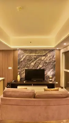 a living room with two beds and a television at Venice Luxe Suite, 1 Bedroom Maximum, 4 adults plus kids in Manila