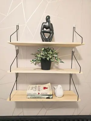 a shelf with a statue and a book and a plant at Casa Celestine Staycation in Manila