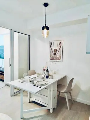 a white dining table and chairs in a room at Vacation Home MOLUAN in Manila