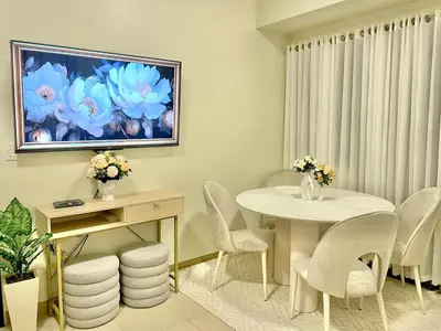 a dining room with a white table and chairs at Manhattan Plaza Suite 1BR with City View, Netflix and Pool Access in Manila