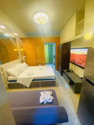 a bedroom with a large bed with towels on it at 232 1br big balcony 2 queen size 1-sofa bed 1single extra mattress in Manila
