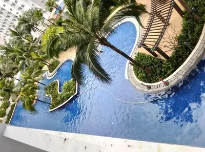 an aerial view of a pool with a palm tree at Urban Haven at Shore Residences Near MOA in Manila