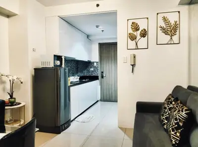a kitchen and a living room with a refrigerator at Urban Haven at Shore Residences Near MOA in Manila
