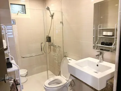 a bathroom with a toilet and a sink and a shower at Unit 2H 81 Newport Boulevard Condominium Perfect for Layovers Across NAIA Terminal 3 in Manila
