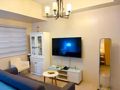 a living room with a blue couch and a tv at Unit 2H 81 Newport Boulevard Condominium Perfect for Layovers Across NAIA Terminal 3 in Manila