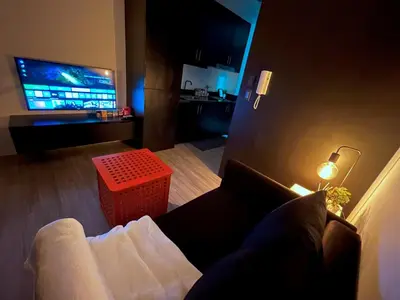 a living room with a couch and a television at Shore 2 Residences - Takya's Staycation in Manila