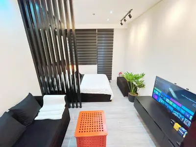 a living room with a couch and a flat screen tv at Shore 2 Residences - Takya's Staycation in Manila