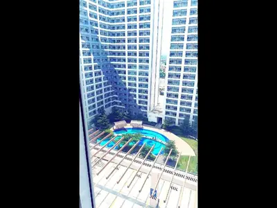 an aerial view of a pool in front of a tall building at Move In Condo in Taguig Fully Furnished in Manila