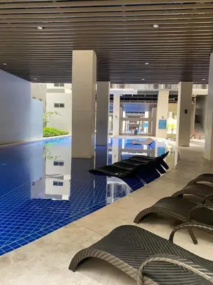 a lobby with a swimming pool in a building at Cozy Family and Group-Friendly Private 2 Bedroom with Coffee Bar and Fast Wifi at S Residences Mall of Asia in Manila