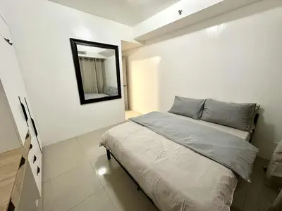 a small bedroom with a bed and a mirror at Shell Residence 2 bedroom by Kathy in Manila