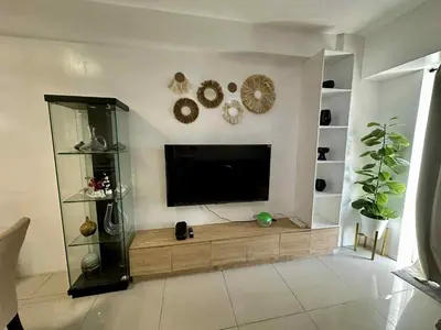 a living room with a flat screen tv on a wall at Shell Residence 2 bedroom by Kathy in Manila