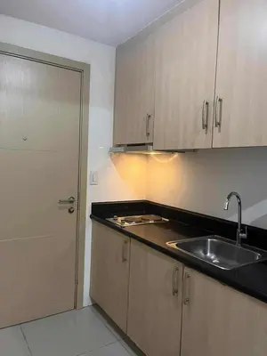 an empty kitchen with a sink and a door at 1 BR Boni LIGHT Condo WIFI Netflix Pool Balcony in Manila