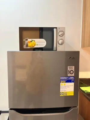 a microwave sitting on top of a refrigerator at Near NAIA Mediterranean Cozy Home with Netflix in Manila