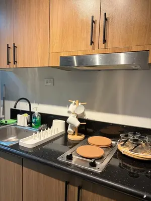 a kitchen counter with a stove and a sink at Near NAIA Mediterranean Cozy Home with Netflix in Manila