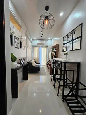 a kitchen and living room with a table and a couch at Near NAIA Mediterranean Cozy Home with Netflix in Manila