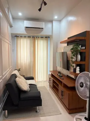 a living room with a black chair and a flat screen tv at Near NAIA Mediterranean Cozy Home with Netflix in Manila