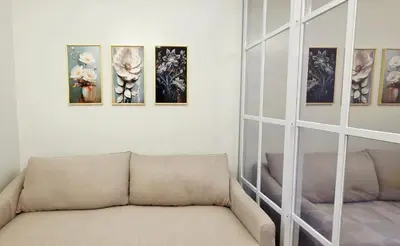 a living room with a couch and paintings on the wall at Executive Saver Suite 1BR Mall of Asia Airport in Manila