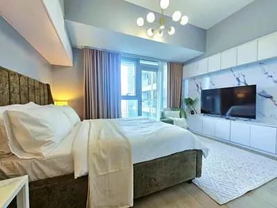 a bedroom with a large bed and a flat screen tv at Uptown BGC Residences by ChiKat in Manila