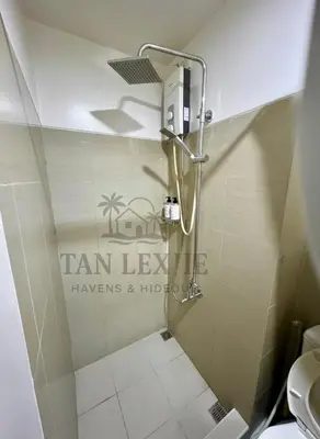 a shower stall in a bathroom with a toilet at Shore Residences by Tan LexJie in Manila