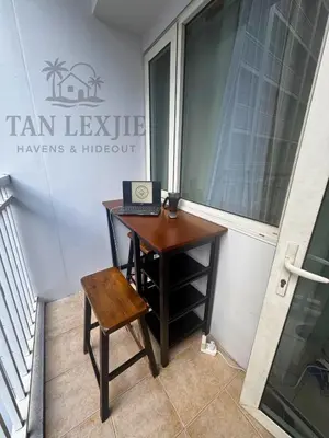 a desk with a laptop and a chair next to a window at Shore Residences by Tan LexJie in Manila