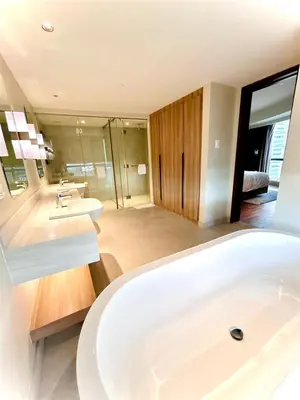 a bathroom with a large white tub and two sinks at Hotel Residences - Novotel Suites Manila at Acqua in Manila