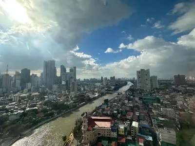a view of a city with a river and buildings at Cleo Suites at Novotel Hotel Residences near Makati in Manila