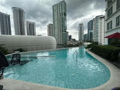 a large swimming pool in a city with tall buildings at Cleo Suites at Novotel Hotel Residences near Makati in Manila