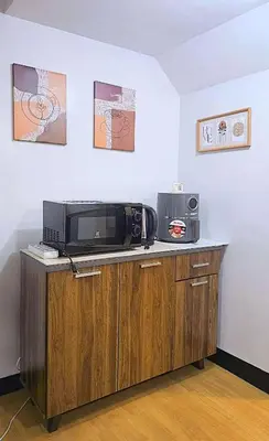 a microwave sitting on top of a counter in a room at Bright & Airy Loft Cambridge Village Charm in Cainta