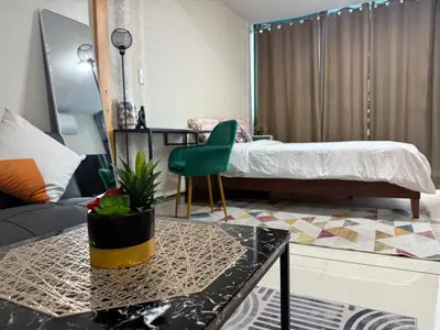 a room with a bed and a table and a couch at One Uptown Residences, BGC, Taguig in Manila