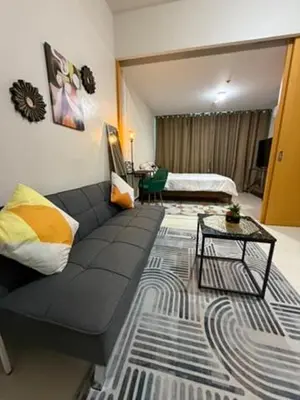 a living room with a couch and a bed at One Uptown Residences, BGC, Taguig in Manila