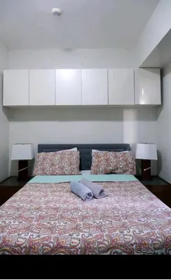 a bedroom with a large bed with two pillows at 5A Southwing in Manila