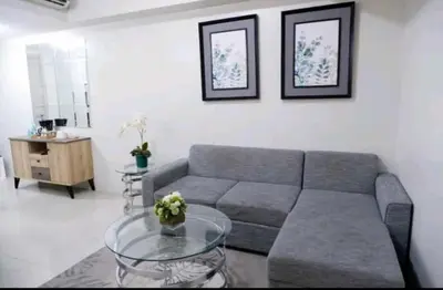 a living room with a couch and a glass table at 5A Southwing in Manila