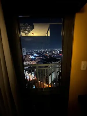 a view of a city at night from a window at David's Cozy Home in Manila