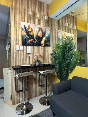 a room with a barber shop with a couch and a plant at David's Cozy Home in Manila