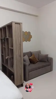 a living room with a couch and a book shelf at Condotels Near Sucat Skyway in Manila