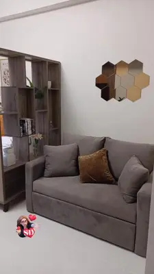 a living room with a couch and a doll on the floor at Condotels Near Sucat Skyway in Manila