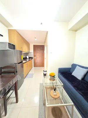 a living room with a blue couch and a kitchen at J&W Homestay in Manila
