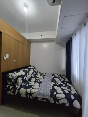 a bedroom with a bed with a black and white comforter at J&W Homestay in Manila