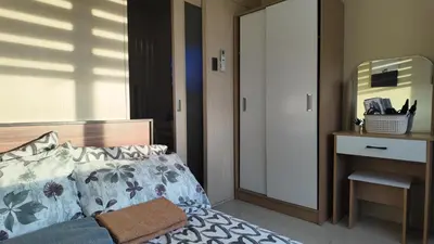 a bedroom with a bed and a dresser with a mirror at Sea Residence 1BR unit 5 to 10 min walk to MOA by Angels Cozy Corner in Manila