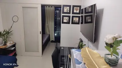 a living room with a couch and a tv at Moa SEA RESIDENCE condotel in Manila