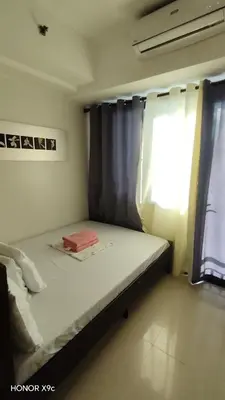 a small bedroom with a bed and a window at Moa SEA RESIDENCE condotel in Manila