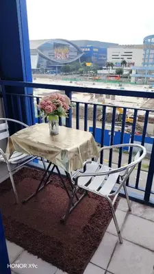 a table with a vase of flowers on a balcony at Moa SEA RESIDENCE condotel in Manila