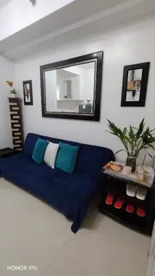 a living room with a blue couch and a mirror at Moa SEA RESIDENCE condotel in Manila