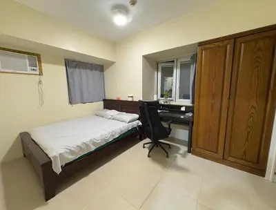 a bedroom with a bed and a desk with a computer at Leo's Master bedroom in Manila