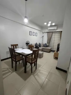 a living room with a table and chairs and a couch at Condotels by San Antonio in Manila