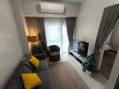 a living room with a couch and a tv at Comfortable and Relaxing 1BR Unit in Manila