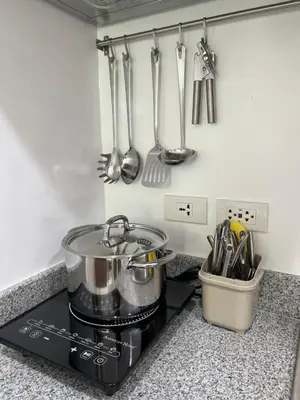 a kitchen with a stove with utensils on the wall at Japan Theme Near Estancia Shaw MRT Kapitolyo Shangrila Mall Megamall Elements in Manila