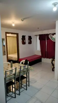 a living room with a table and chairs and a bed at 2BR Condo FF, Great View, Taguig ,UNDER RENOVATION in Manila