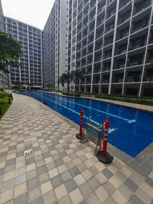 a swimming pool in front of a tall building at MOA Staycation in Manila